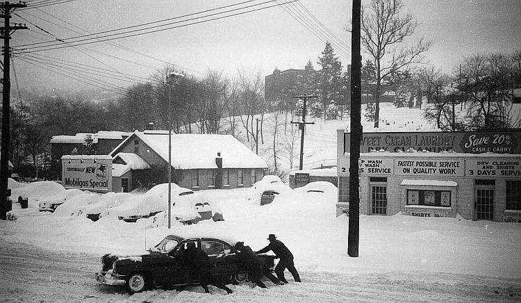 Men push an automobile through the snow after
the Thanksgiving Day Blizzard of 1950.