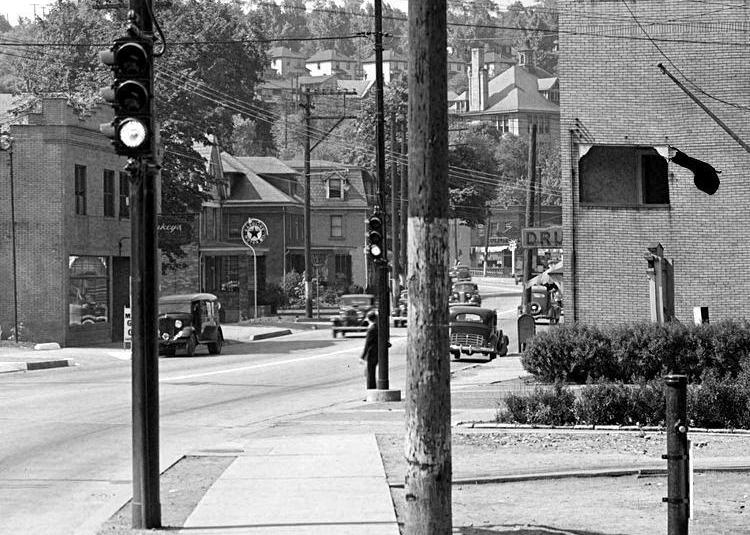 A pedestrian waits for car traffic to pass
before crossing near Maytide Street in 1936.