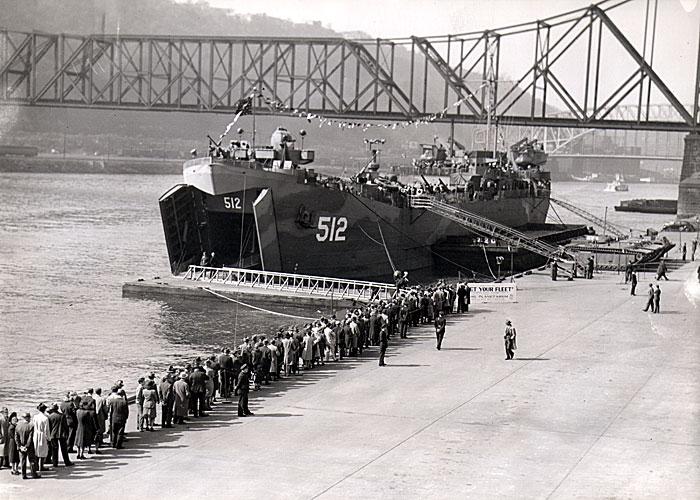 LST-512 moored on the banks of
the Monongahela River in Pittsburgh.
A long line of visitors awaits the
chance to view the war exhibits.