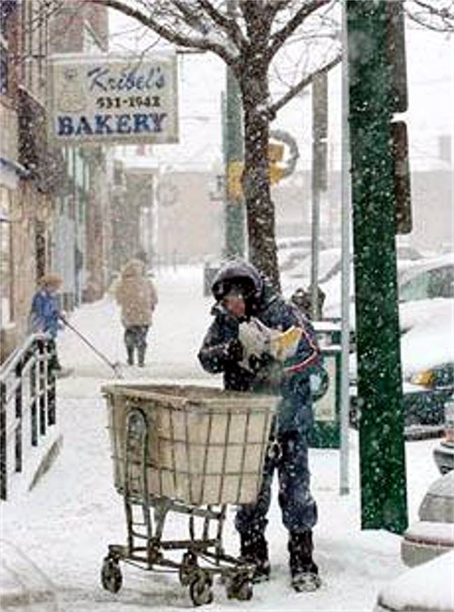 A mailman sorting through his cart during
a snowstorm along Brookline Boulevard.