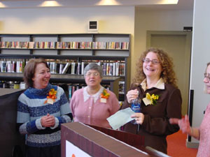 Brookline's Peg, Judy, Holly
McCullough (Branch Manager), and Ginny
try out the podium before the grand opening.