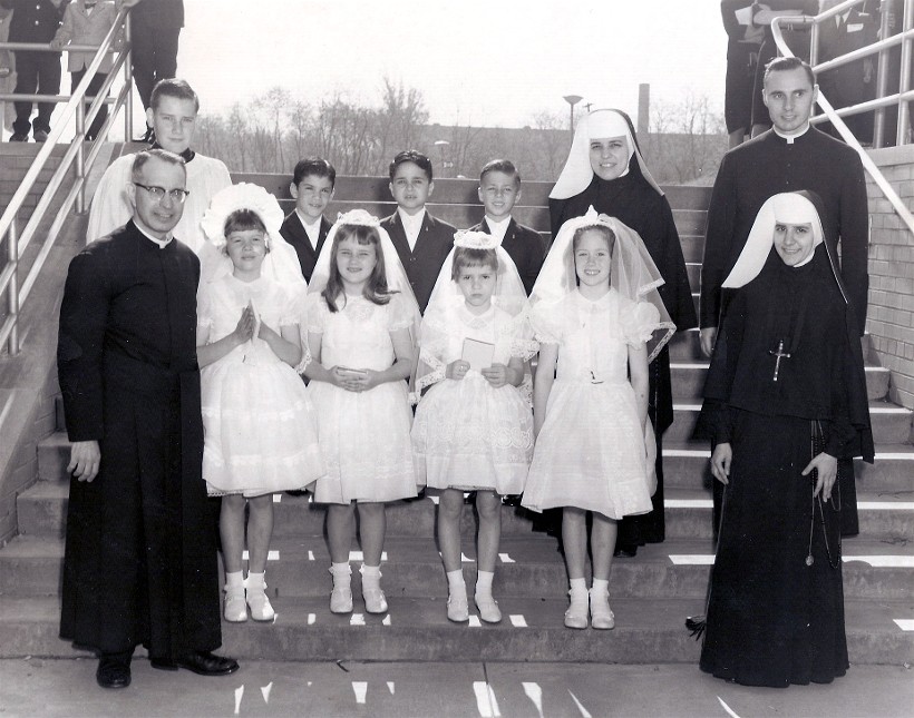 Father James Woods (right), shown here
with a group of second graders after
First Holy Communion on May 15, 1966.
Also pictured are Fr Garbin, Sr Ann
Marie and Sr Francine. Altar Boy Richard
Seiler went on to the priesthood in 1980.